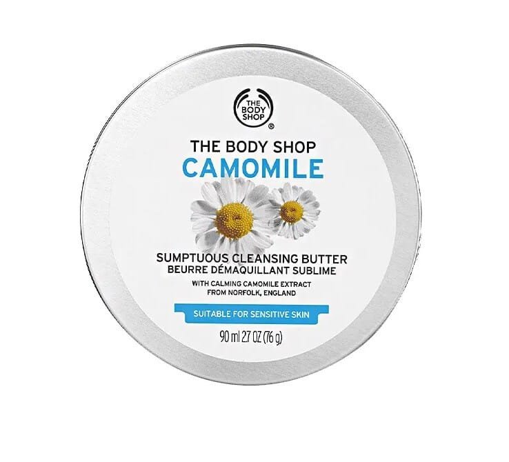Envase redondo de manteca limpiadora The Body Shop Camomile de 90 ml, adecuada para piel sensible, elimina eficazmente el maquillaje, incluso el resistente al agua, mientras calma y cuida la piel. Enriquecida con extracto de manzanilla proveniente de Norfolku Inglaterra, tiene textura sedosa se funde en contacto con la piel, disolviendo impurezas sin dejar sensación grasosa. Proporciona una limpieza profunda y una experiencia sensorial relajante para tu rostro.