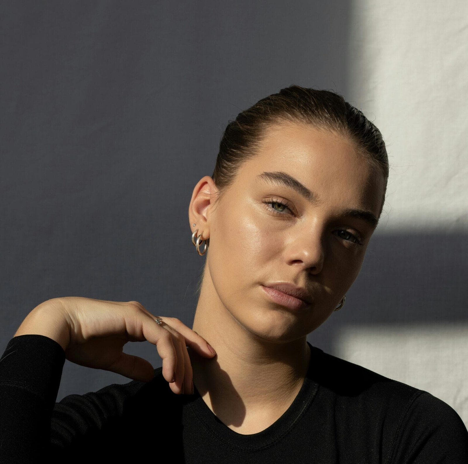 Fotografia de una mujer con piel radiante y maquillaje natural. Belleza natural y elegante. Moda y estilo, accesorios de plata, cejas definidas y un look sofisticado. Tendencias en skincare, cuidado de la piel y fotografía de belleza.
