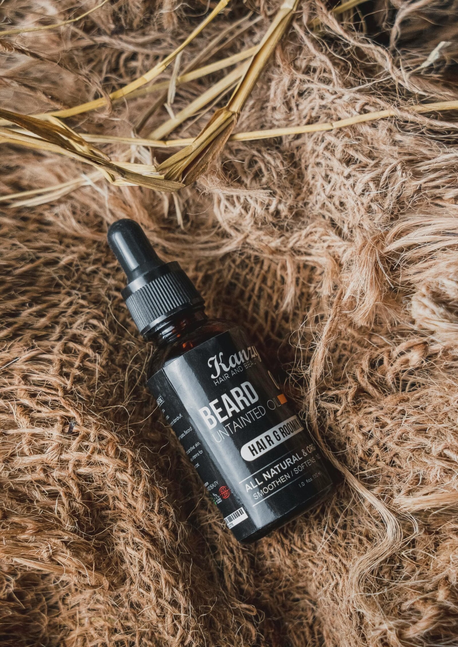 frasco negro de aceite para crecimiento de la barba en fondo cafe, minoxidil, tratamiento para barba, crecimiento de barba. Loción facial