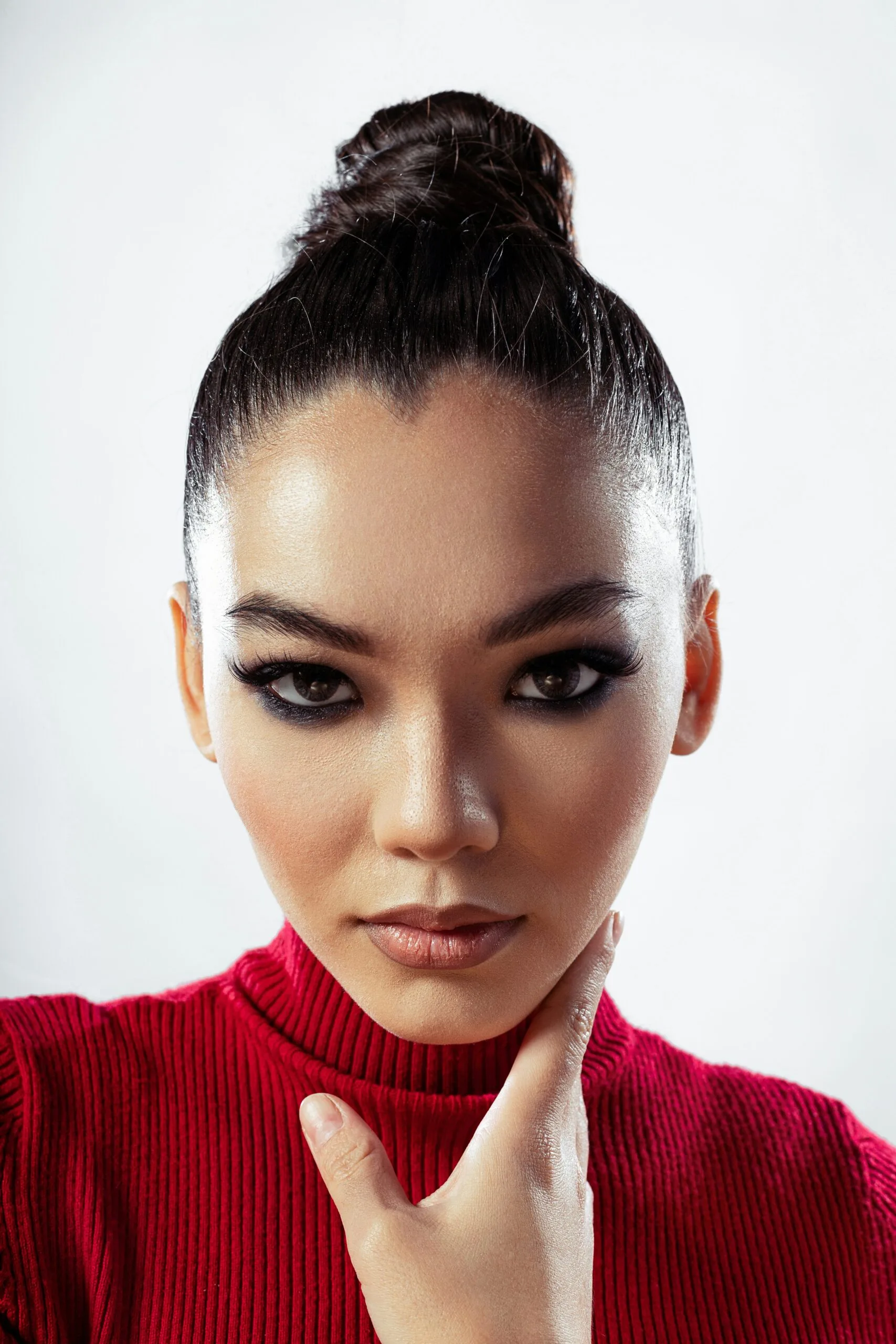 Mujer con rostro en forma de corazón, con un maquillaje cargado y resaltando, sombra de ojos, cejas definidas, piel brillante, maquillaje de noche, tendencia en maquillaje.