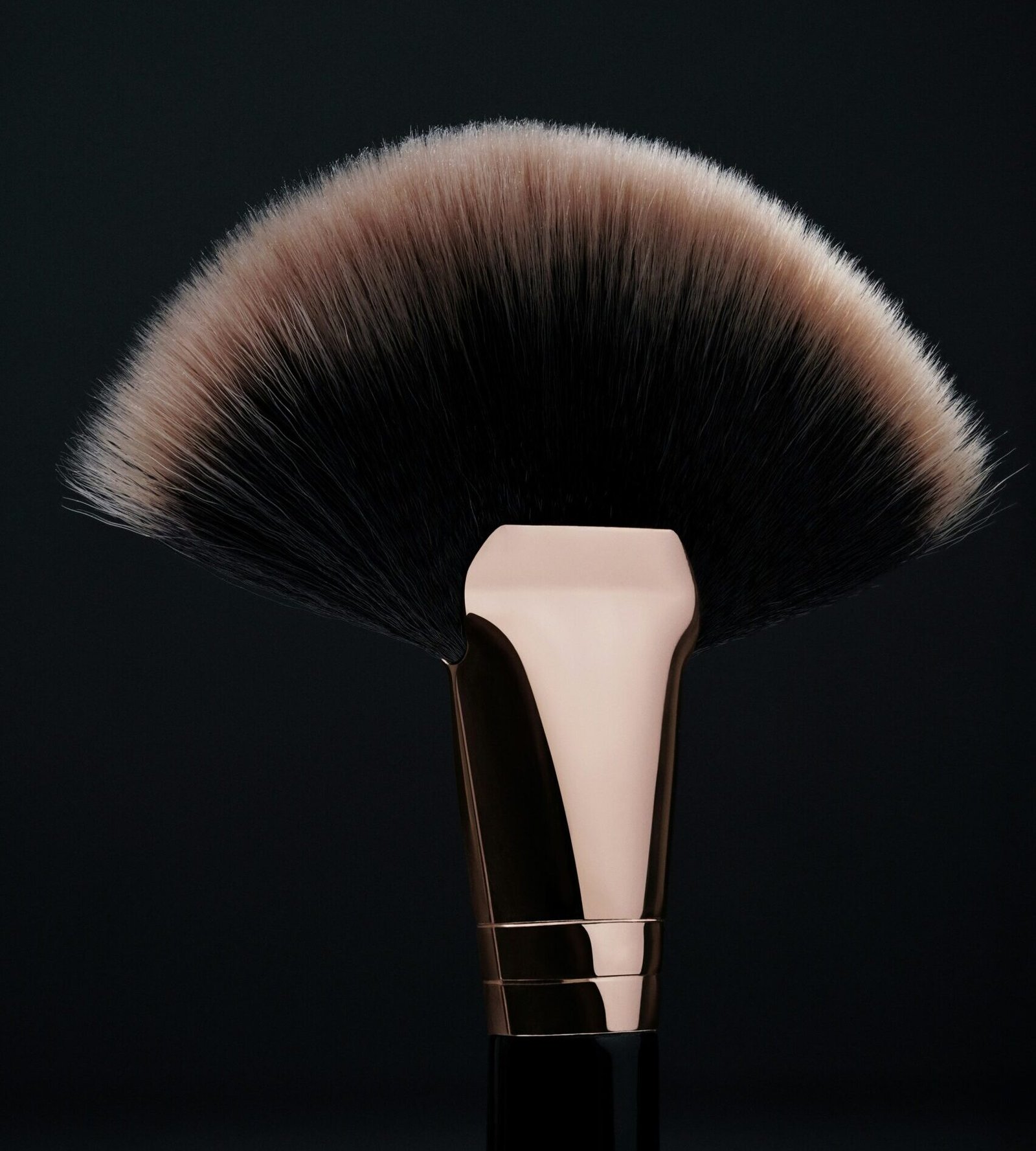 Brocha de maquillaje profesional tipo abanico con cerdas suaves y mango metálico elegante. Herramienta esencial para la aplicación de iluminador, polvos y contorno. Accesorio de belleza ideal para maquillaje profesional y principiantes. Brochas de alta calidad, cosmética de lujo y tendencias en herramientas de maquillaje.